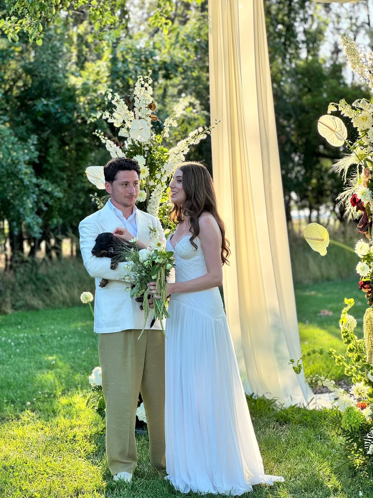 A couple sharing a moment beneath their ceremony arch