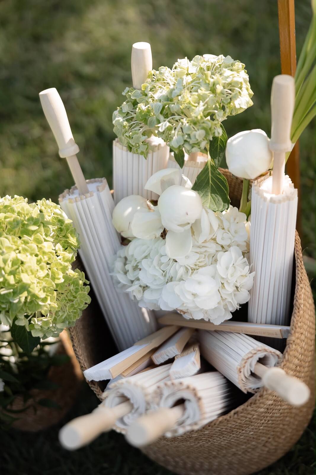 A basket of hand fans and hydrangeas prepared as a guest welcome touch
