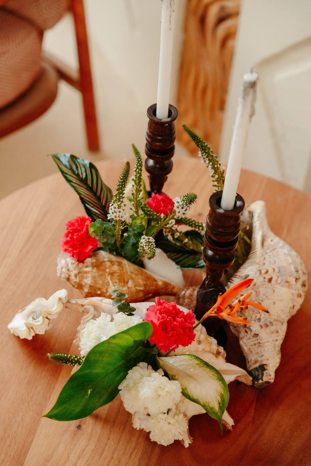 A centerpiece built from shells, carnations and taper candles